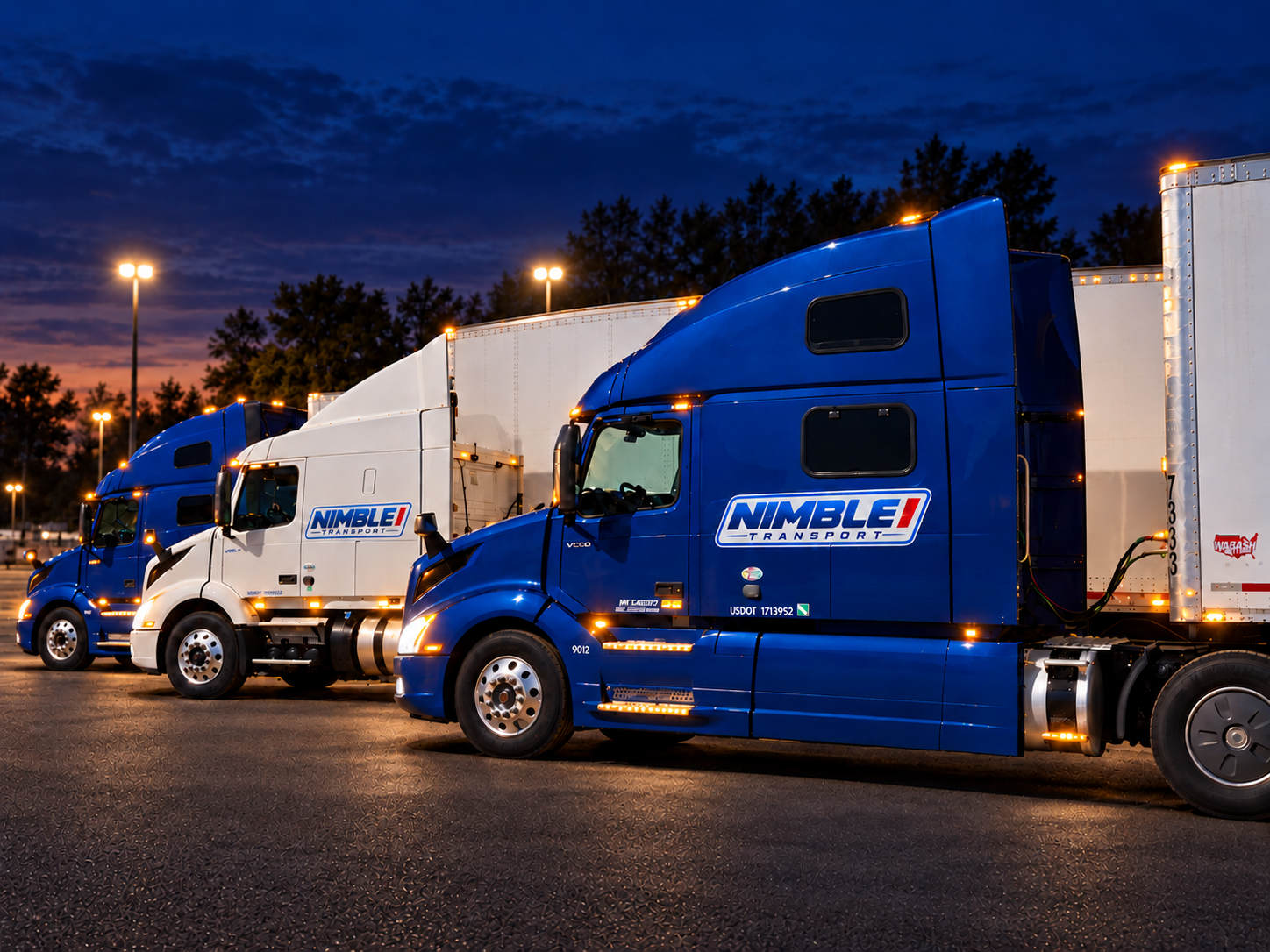 Three Nimble Transport trucks lined up at night